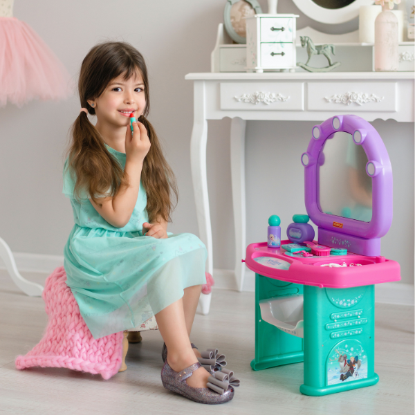 Bambina che si applica il rossetto nella sua cameretta.