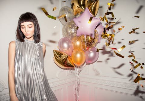 Giovane donna con trucco festa di compleanno realizzato da Noemi Spera Make Up Artist, circondata da palloncini colorati e coriandoli, in occasione di una festa di compleanno.