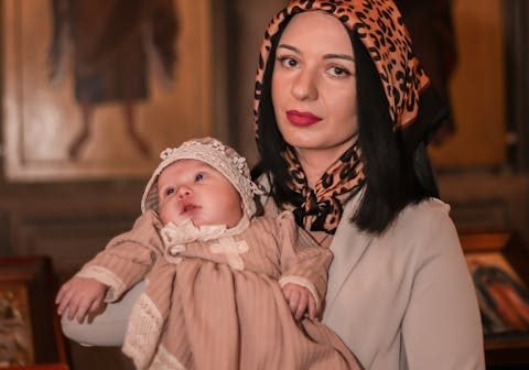 Mamma truccata splendidamente da Noemi Spera Make Up Artist che tiene in braccio suo figlio nel giorno del suo battesimo.